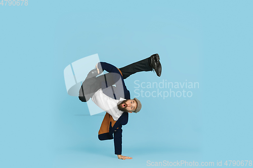 Image of Businessman having fun dancing break dance on blue background at work