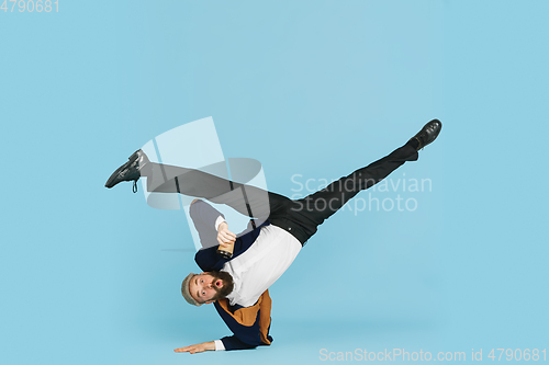 Image of Businessman having fun dancing break dance on blue background at work