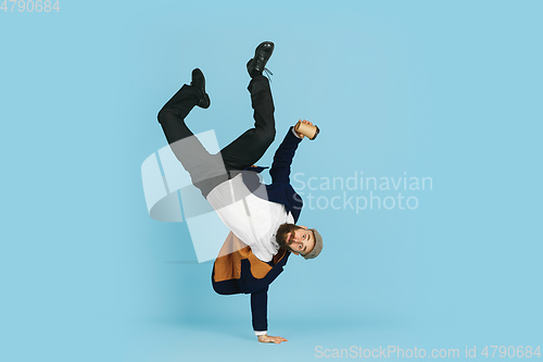 Image of Businessman having fun dancing break dance on blue background at work