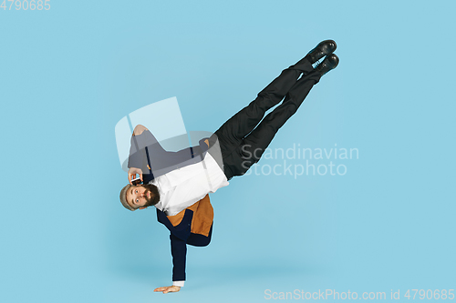 Image of Businessman having fun dancing break dance on blue background at work