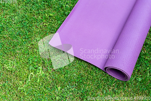 Image of Fitness mat on the green grass background