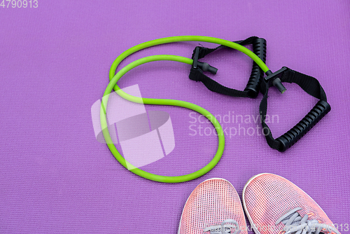 Image of Sneakers, fit tube and a purple fitness mat. Sport concept