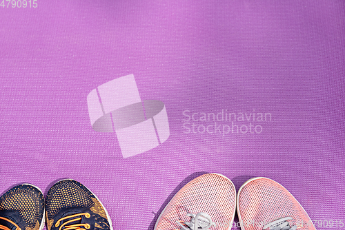 Image of Sneakers and a purple fitness mat. Sport concept