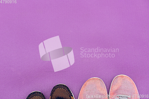 Image of Sneakers and a purple fitness mat. Sport concept