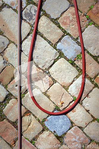 Image of water hose on a cobble stone floor