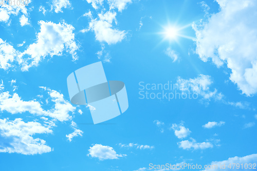 Image of typical blue sky with sun and clouds background