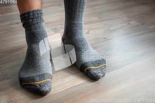 Image of male feet in grey socks on a wooden floor