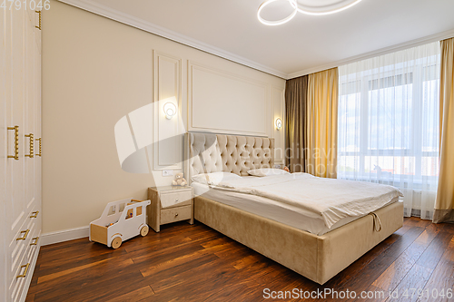 Image of Beige colored modern bedroom interior with double bed