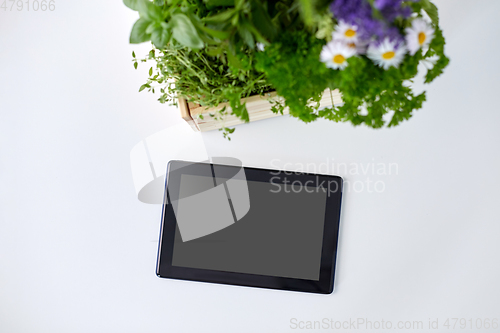 Image of tablet computer with herbs and flowers in box