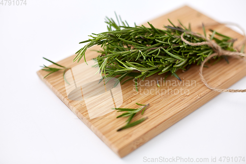 Image of bunch of rosemary on wooden cutting board