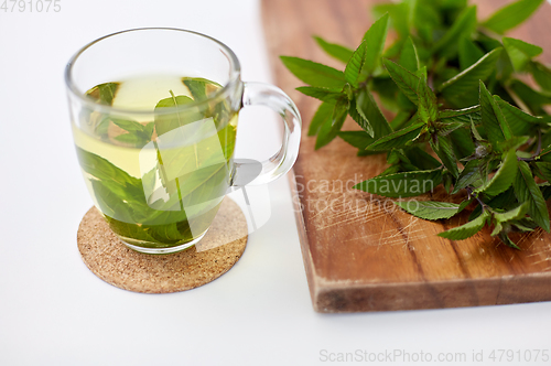 Image of herbal tea with fresh peppermint on wooden board