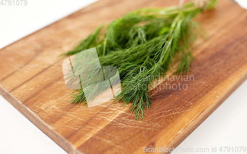 Image of bunch of dill on wooden cutting board