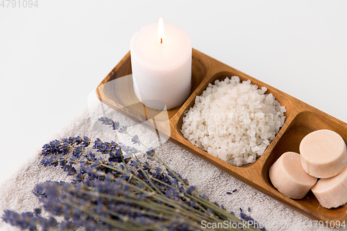 Image of sea salt, soap, candle and lavender on bath towel