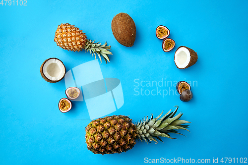 Image of pineapple, passion fruit and coconut on blue