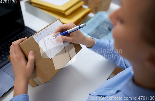 Image of close up of woman filling postal form at office