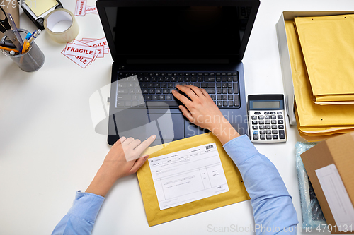Image of hands with laptop and envelope at post office