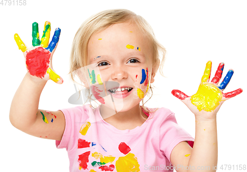 Image of Portrait of a cute little girl playing with paints