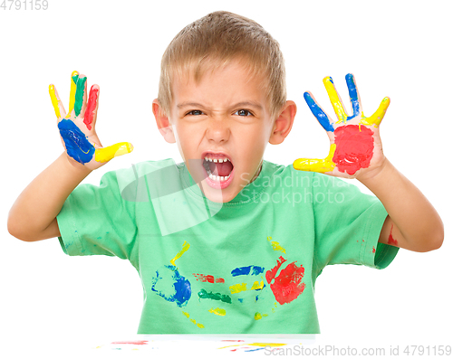 Image of Portrait of a cute boy playing with paints