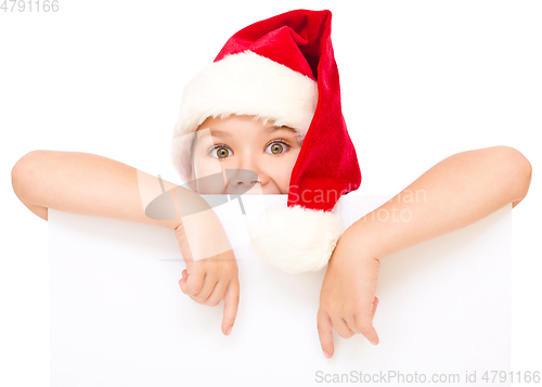 Image of Little girl in santa hat is holding blank board