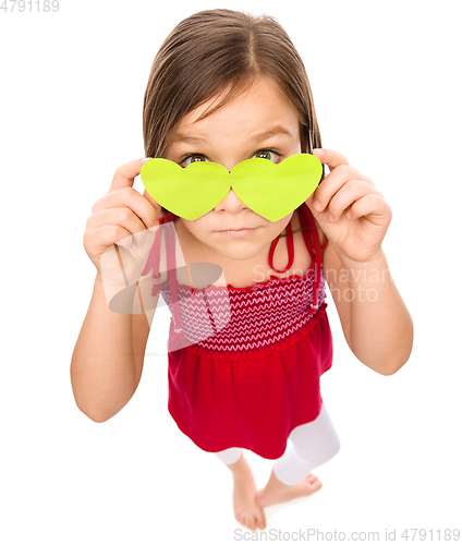 Image of Little girl is holding hearts over her eyes