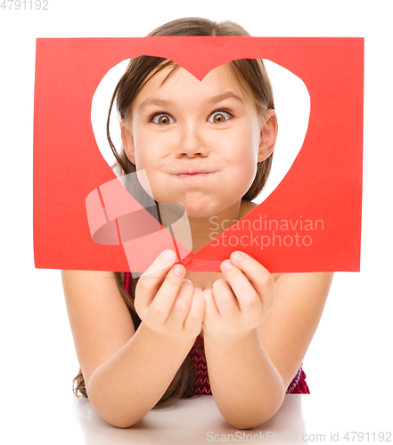 Image of Little girl is looking through heart template
