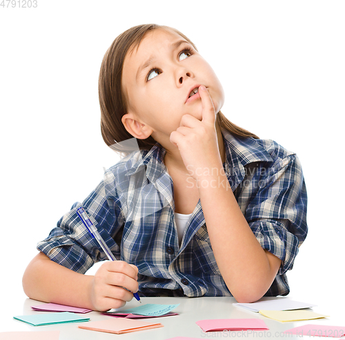 Image of Girl is writing on color stickers using pen