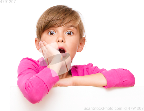 Image of Little girl is looking out from the blank banner