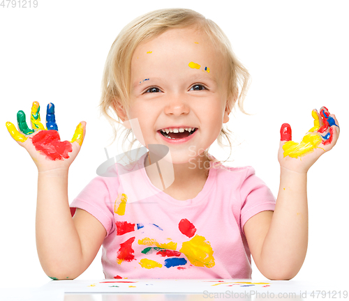 Image of Portrait of a cute little girl playing with paints