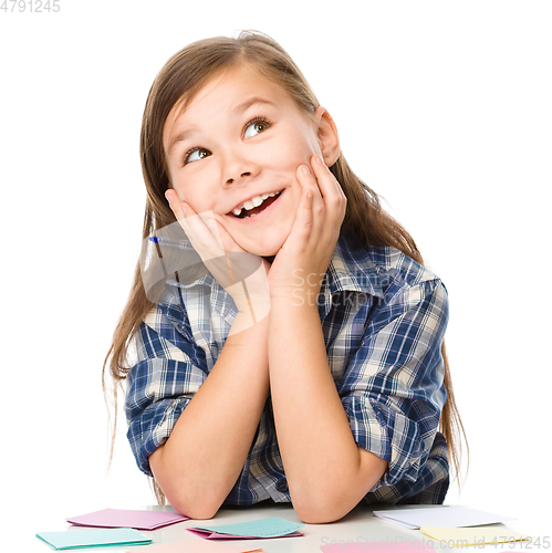Image of Girl is writing on color stickers using pen