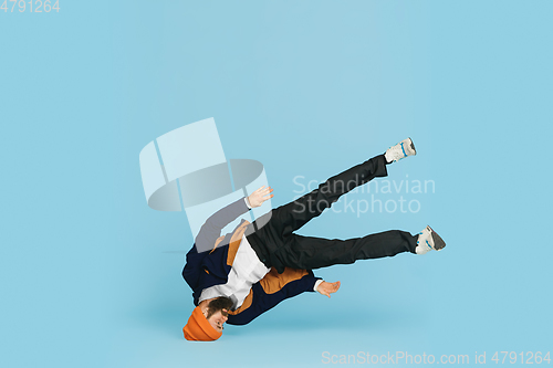 Image of Businessman having fun dancing break dance on blue background at work