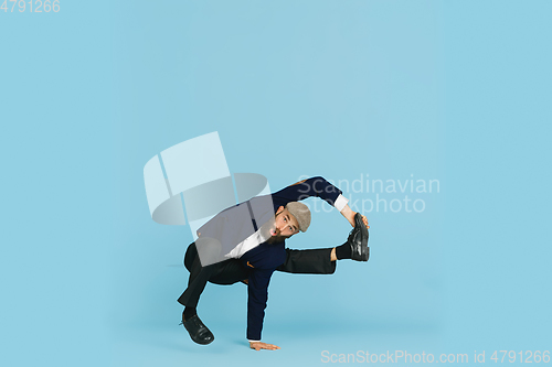 Image of Businessman having fun dancing break dance on blue background at work