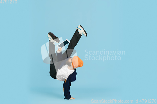 Image of Businessman having fun dancing break dance on blue background at work