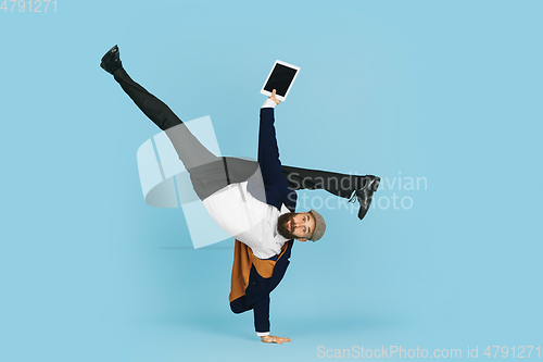 Image of Businessman having fun dancing break dance on blue background at work