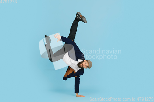 Image of Businessman having fun dancing break dance on blue background at work