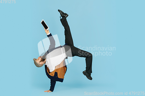 Image of Businessman having fun dancing break dance on blue background at work