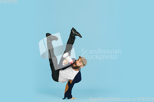 Image of Businessman having fun dancing break dance on blue background at work