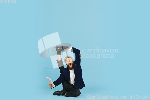 Image of Businessman having fun dancing break dance on blue background at work