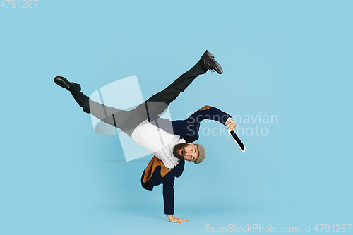 Image of Businessman having fun dancing break dance on blue background at work