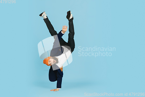 Image of Businessman having fun dancing break dance on blue background at work