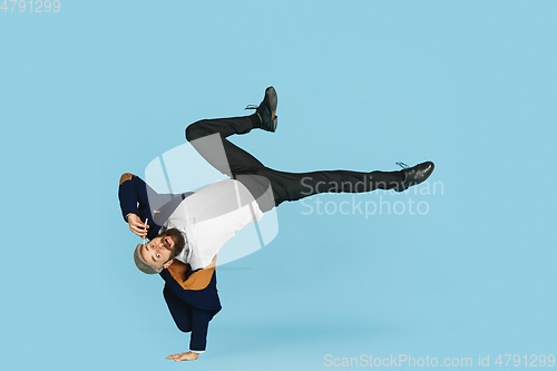 Image of Businessman having fun dancing break dance on blue background at work