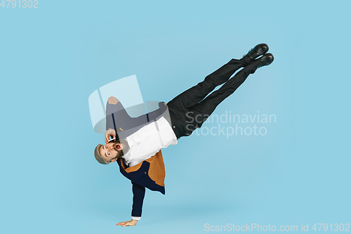 Image of Businessman having fun dancing break dance on blue background at work