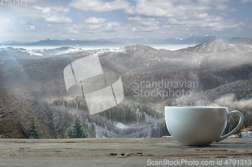 Image of Single tea or coffee mug and landscape of mountains on background