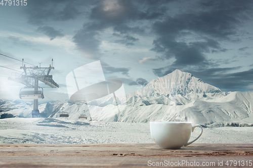 Image of Single tea or coffee mug and landscape of mountains on background