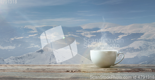 Image of Single tea or coffee mug and landscape of mountains on background