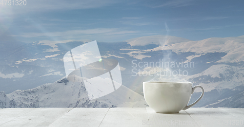 Image of Single tea or coffee mug and landscape of mountains on background