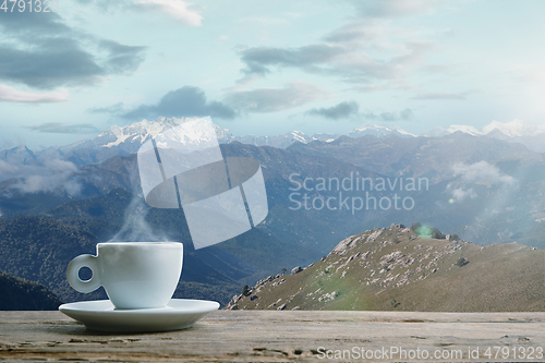 Image of Single tea or coffee mug and landscape of mountains on background