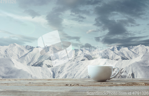 Image of Single tea or coffee mug and landscape of mountains on background