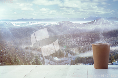 Image of Single tea or coffee mug and landscape of mountains on background