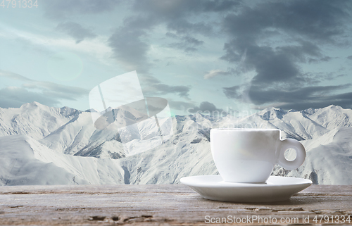 Image of Single tea or coffee mug and landscape of mountains on background