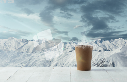 Image of Single tea or coffee mug and landscape of mountains on background
